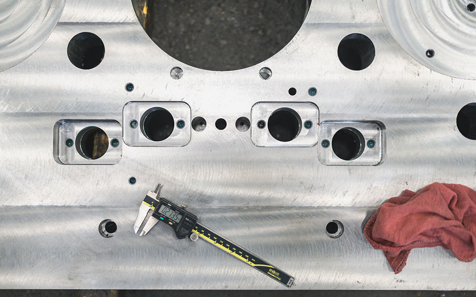 A measurement tool sits on a metal tooling die.